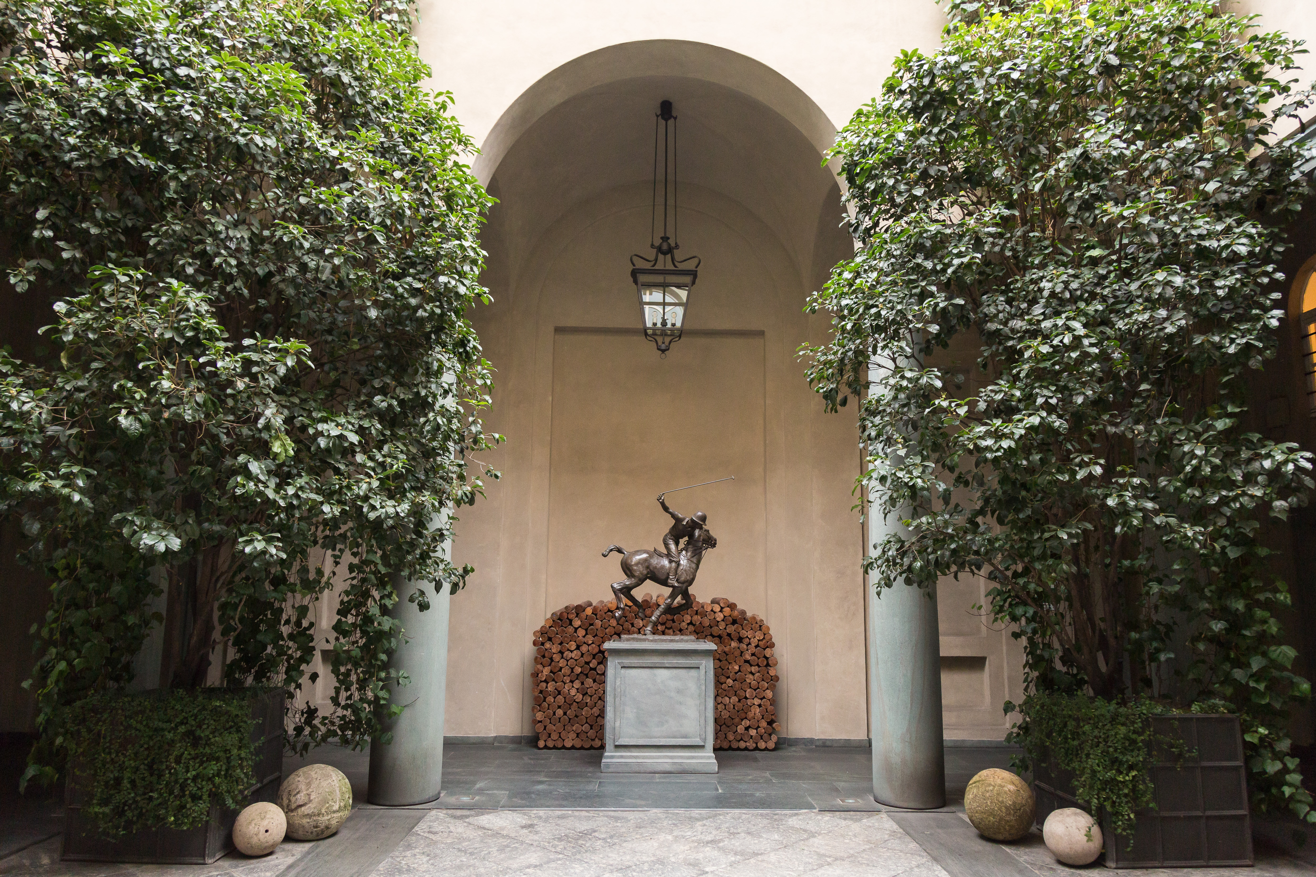 Grönskande valv och en staty av en polospelare i Ralph Laurens Palazzo i Milano.