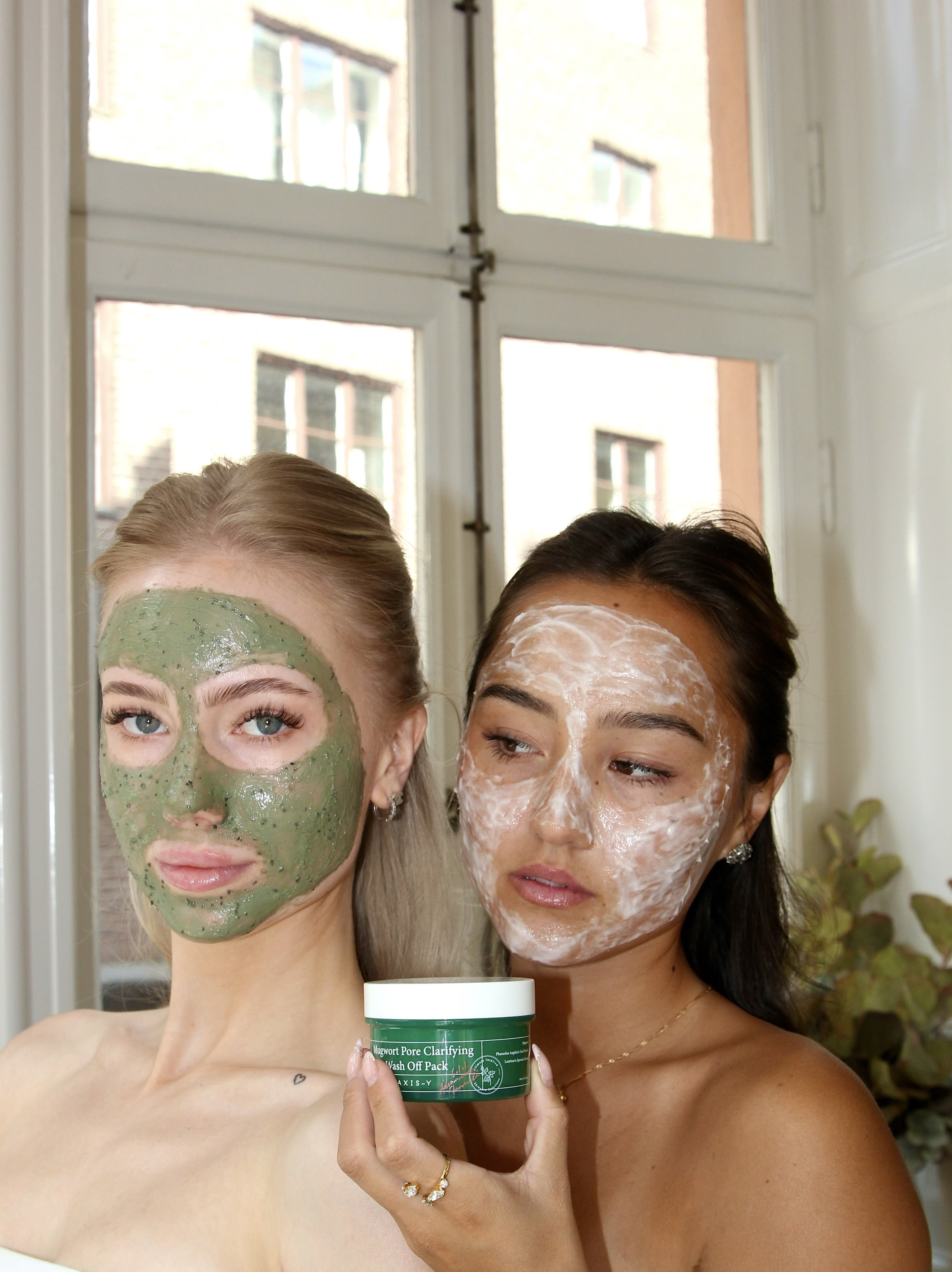 Nova och Tilda med ansiktsmasker och en hudvårdsprodukt.